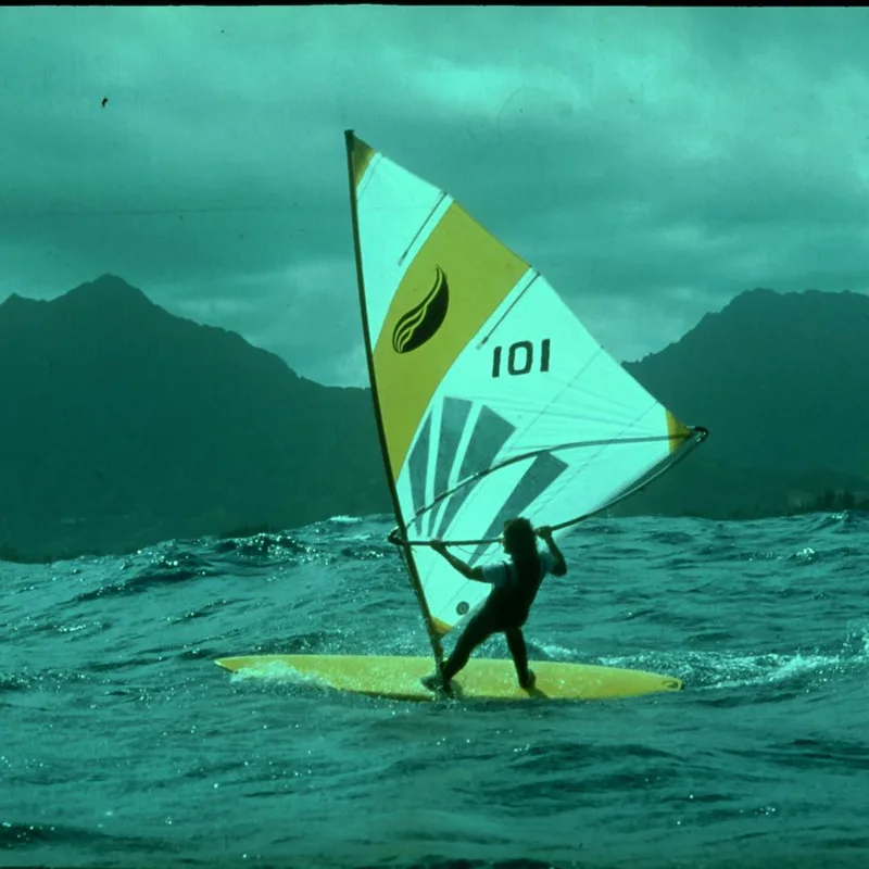 Windsurfer op een geel board uit de jaren tachtig